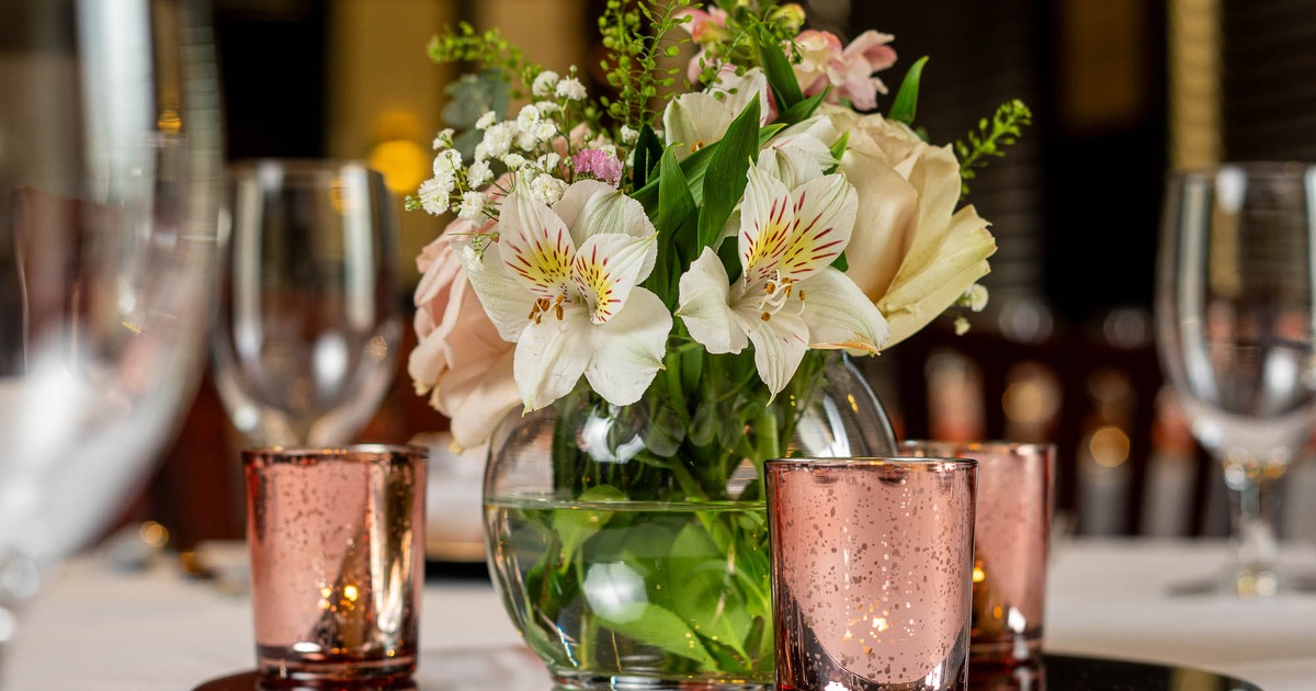 Flower display and candles on a table, close up