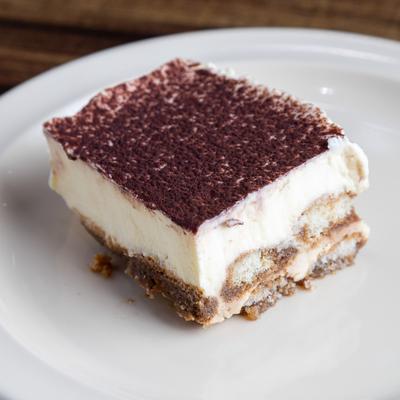 A slice of tiramisu on a white plate.