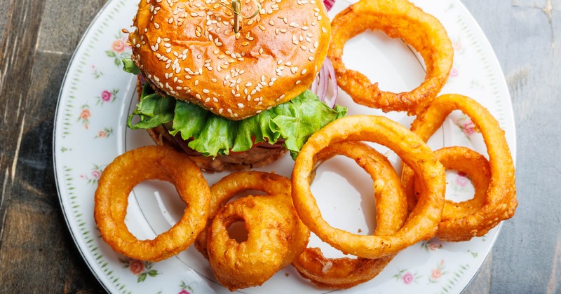Signature burger served with a side of onion rings