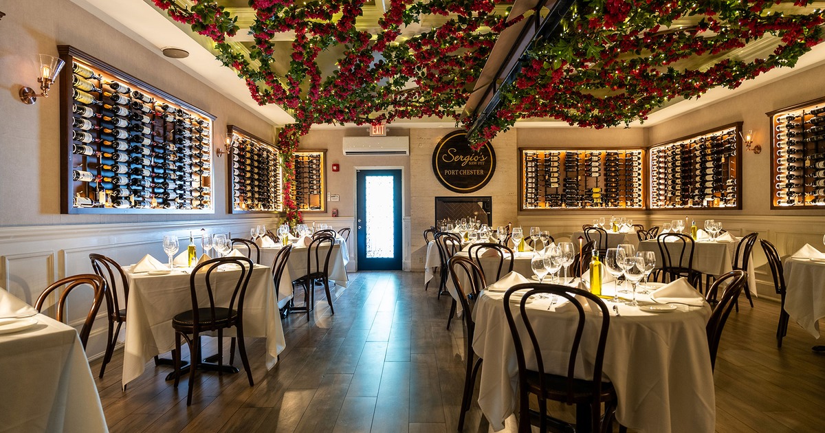 Restaurant interior, dining room with wine racks and set tables