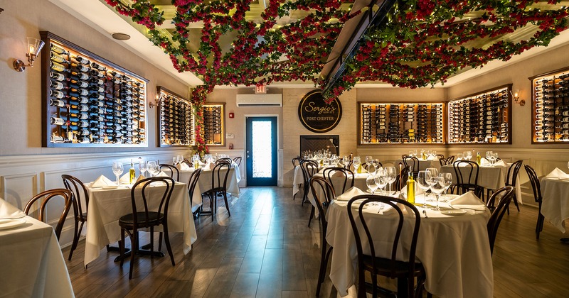 Restaurant interior, dining room with wine racks and set tables