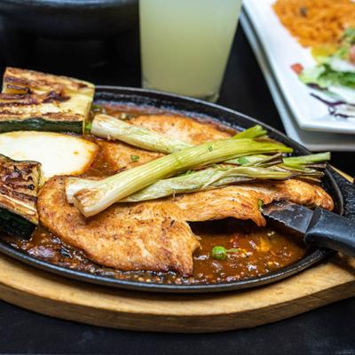 Grilled chicken served with grilled vegetables and Mexican sauces