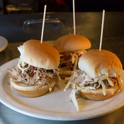Pulled Pork Sliders topped with coleslaw and served on the plate.