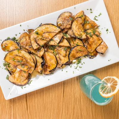 Eggplant chips paired with a blue cocktail.
