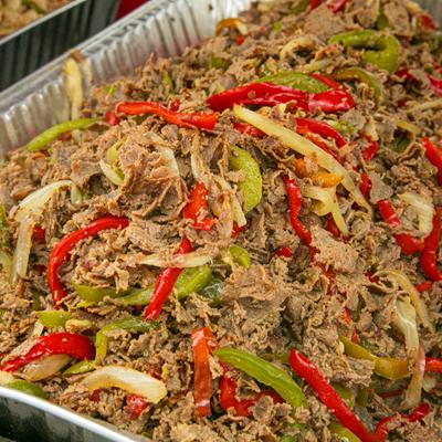 Catering tray with shredded steak, peppers and onion.