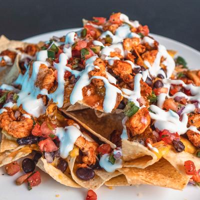 Nachos topped with cheese, beans, chili and sour cream