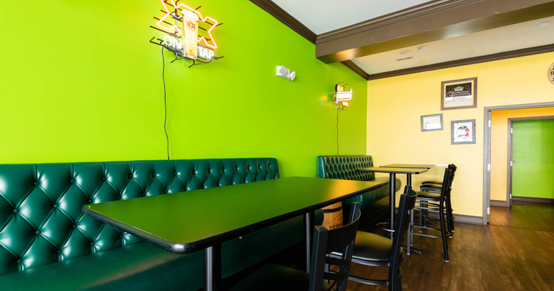 Interior, button tufted seating with tables and chairs beside a wall