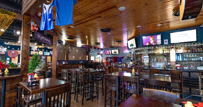 Interior, high tables and stools, and bar area with TV sets