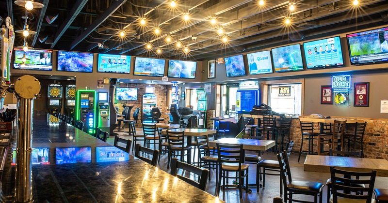 Interior, bar area, seating, lots of TVs on walls