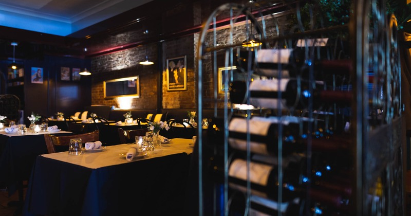 Diner room, wine rack in front of a diner set-up tables