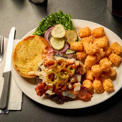 Burger topped with cheese, bacon and jalapenos, served with tater tots.