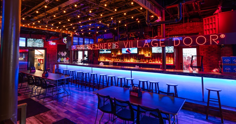 Interior featuring a long bar with neon blue under-lighting and high chairs