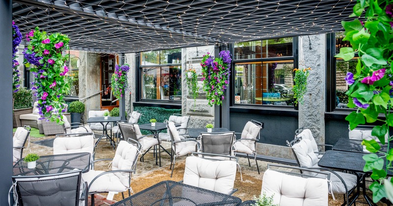 Interior, partially covered seting area, tables for four, lavish floral decoration