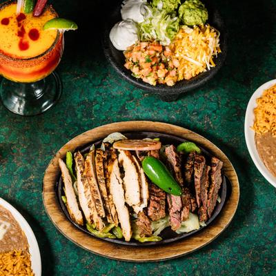 Grilled meat, rice, sauce, salad, two cocktails on the side