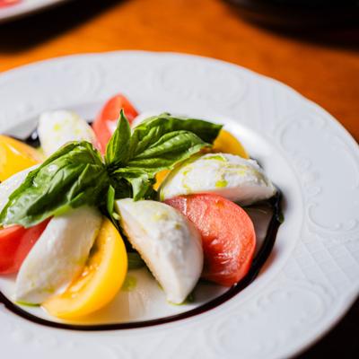 Caprese salad with tomato, mozzarella, and basil leaves.