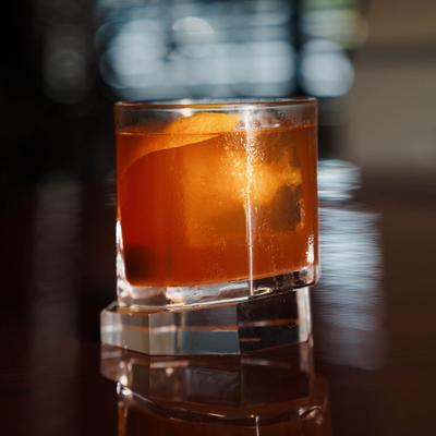 Old Fashioned cocktail garnished with an orange peel.