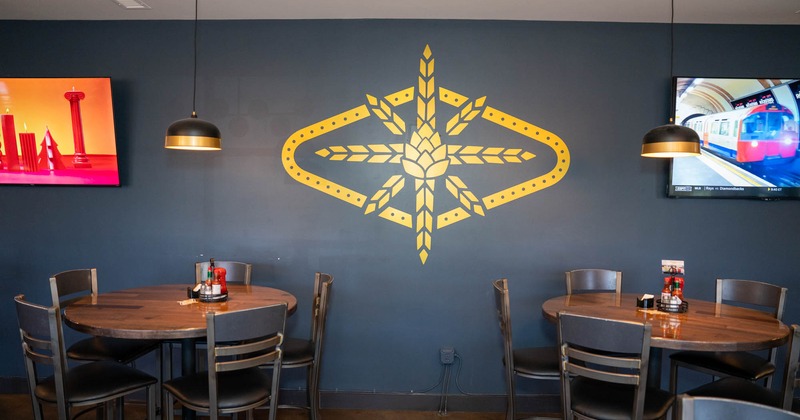 Seating area, painted decoration on the wall,  and TV screens