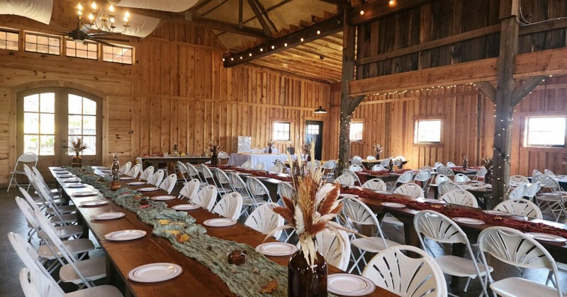 Interior, long wooden table setups with chairs, large event space, wooden interior details