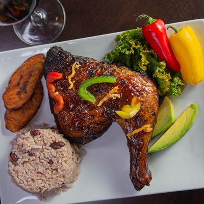 Roasted half chicken served with plantains, rice, bell peppers and avocado