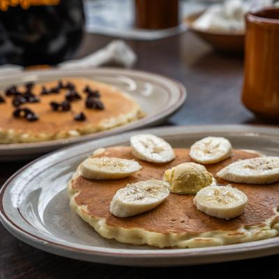 Buttermilk pancake topped with butter and banana slices.