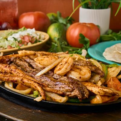 Sizzling mixed fajitas with shrimp, steak, and shrimp.