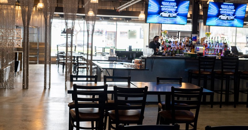 Interior, dining tables, bar area with large TV screens