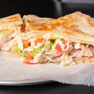 Toasted ham sandwich with lettuce, tomato, and mayo.