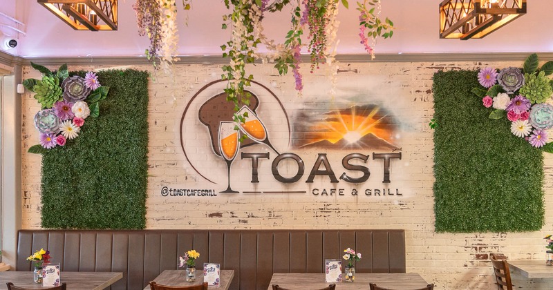 dining area with flower design on the wall with restaurant logo on the wall