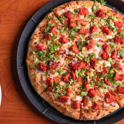 Tandoori Chicken Pizza topped with green onions.