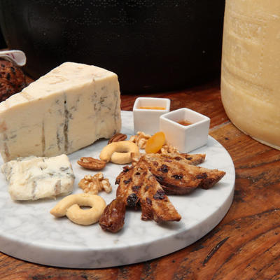 Cheese board with side walnuts, dried apricot, focaccia, and condiments