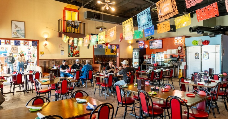 Colorful restaurant dining room with hanging papel picado banners