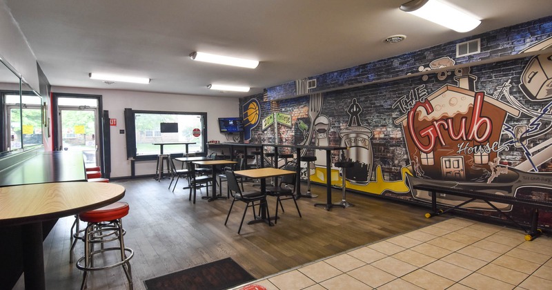 Interior, dining area, high and regular seating tables with chairs, restaurant entrance