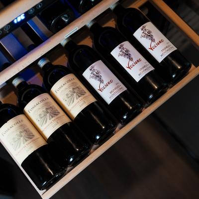 Bottles of red wine on a wooden rack.