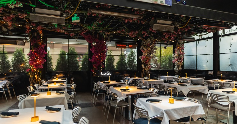 Cozy, semi-outdoor dining area with flower decorations on the ceiling