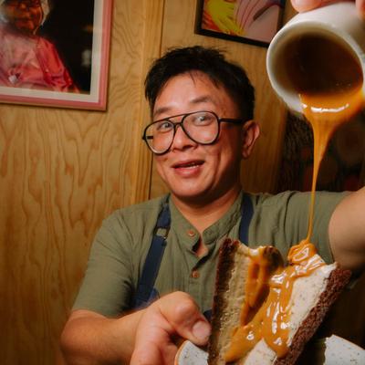Person pouring sauce over a stuffed flatbread.