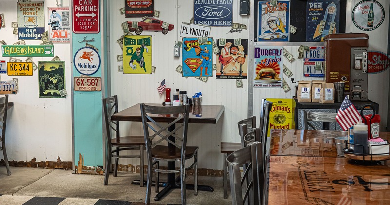Interior dining area, walls decorated with vintage signs, retro advertisements, license plates