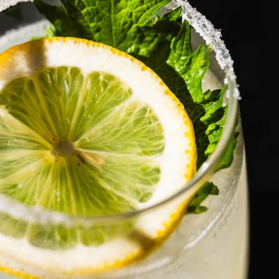 Cocktail with a lime wedge and mint.