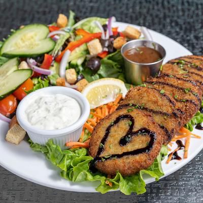 Crab cakes, served with salad, and mango chutney dipping sauce.