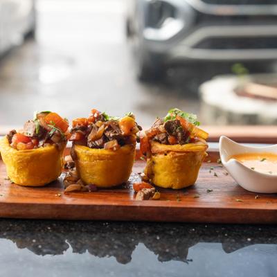 Plantain cups stuffed with steak and pico de gallo, served with dipping sauce.