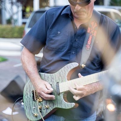 Outdoors, a guitarist performing.