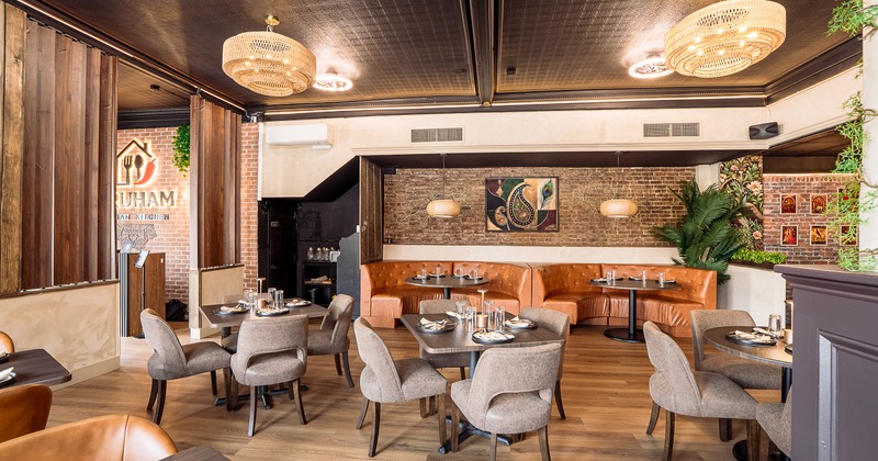 Interior of modern and cozy dining area with dining tables set for guests