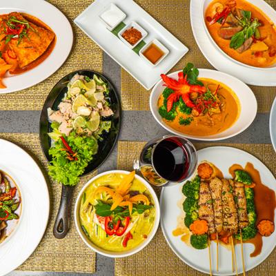 Variety of dishes served on the table with a glass of wine.