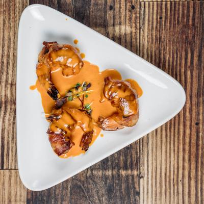 Bacon-wrapped shrimp served in a creamy bourbon sauce.