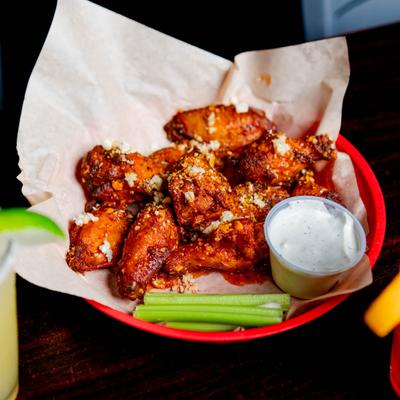 Chicken wings served with sauce and celery.