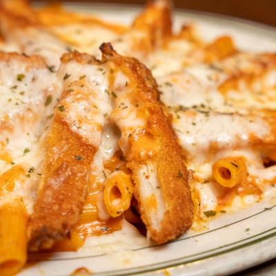 Fried chicken with penne pasta and melted cheese.
