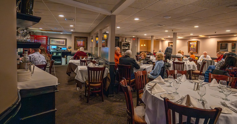 Interior, dining area with set tables, guests chatting and enjoying their food and drinks