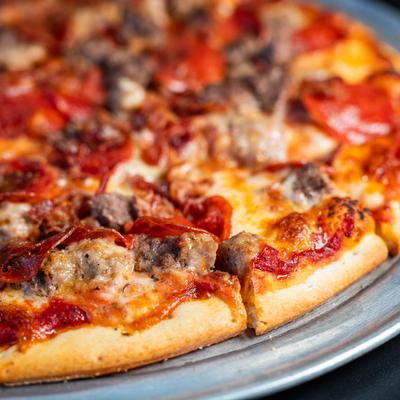 Supreme pizza with sausage and pepperoni, close-up.