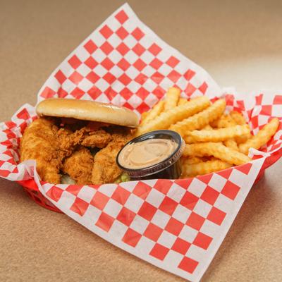 A basket with a chicken tender sandwich and crinkle-cut fries..
