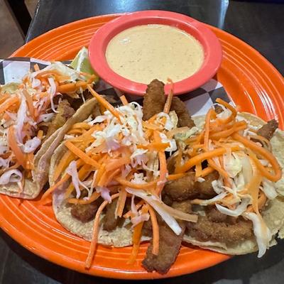 Fish tacos served on a plate with chipotle crema.