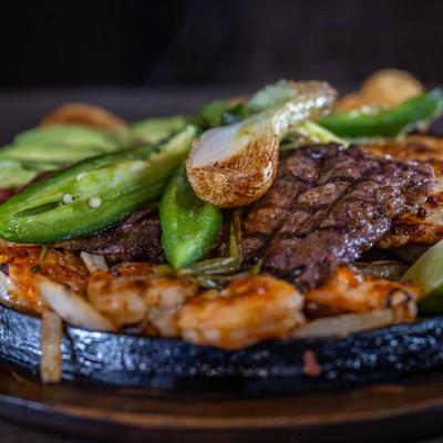Grilled steak and shrimp with green peppers, close-up.